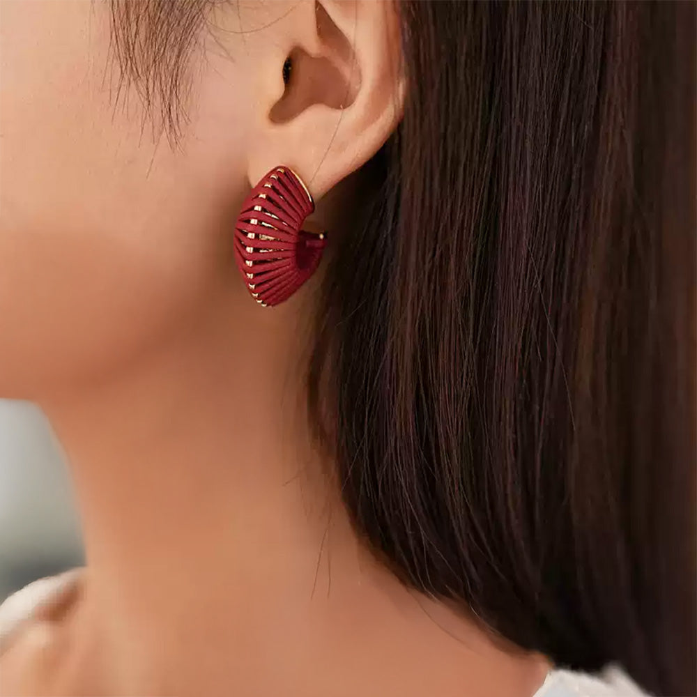 Red ribbed clip-on hoop earrings side view worn on model with long dark hair