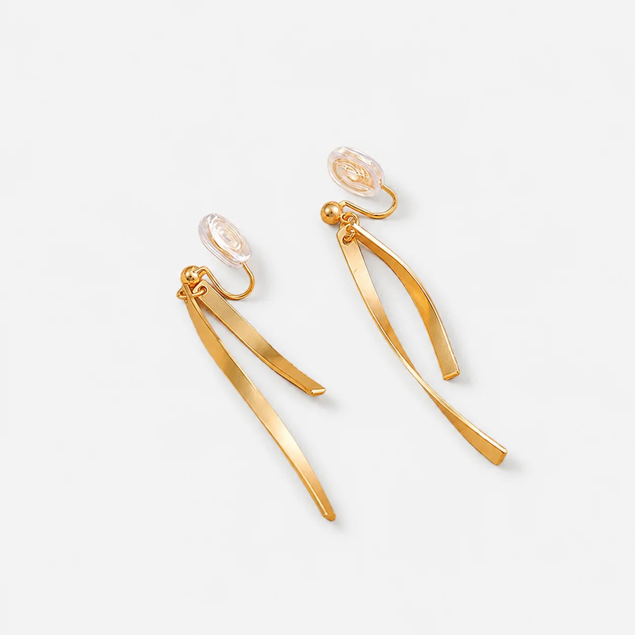 A pair of gold-toned dangle earrings with curved ribbon-like drops, photographed on a clean white background.