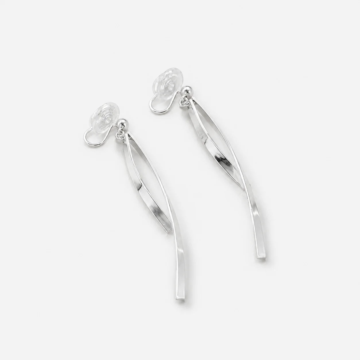 A pair of silver drop earrings with a polished, curved ribbon-like design, shown on a light gray background.
