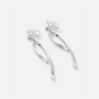 A pair of silver-toned dangle earrings with a modern, flowing ribbon-like design, shown on a clean light gray background.