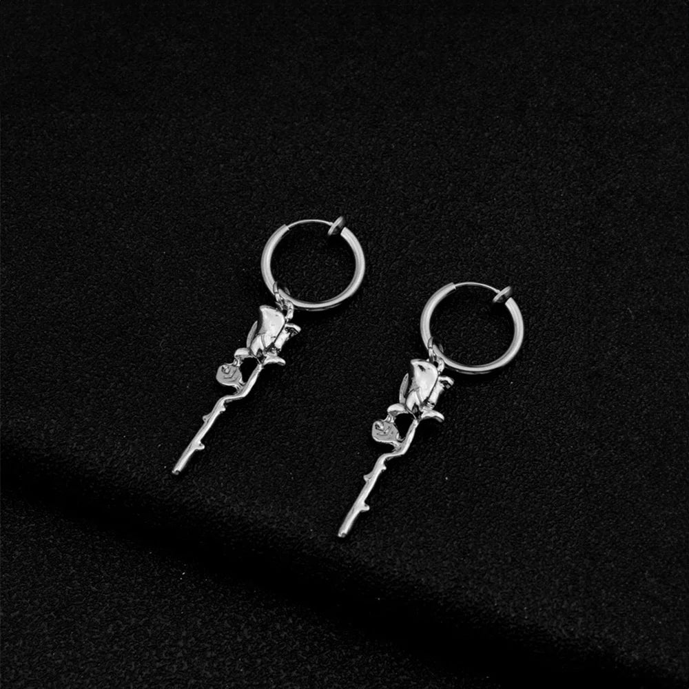 Silver rose vine clip-on hoop earrings displayed on black background, showing detailed floral design and polished metal finish
