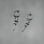 Silver rose vine clip-on hoop earrings displayed on white background, showing detailed botanical design from front angle