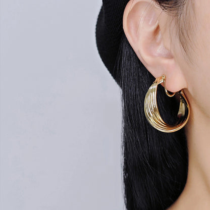 Rotating Spiral Clip-On Hoop Earrings worn by a model, emphasizing their bold and dynamic design.