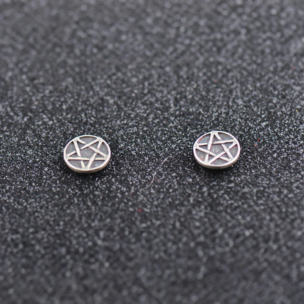 A pair of Sterling Silver Aged Star Magnetic Stud Earrings, laid out on a textured surface.