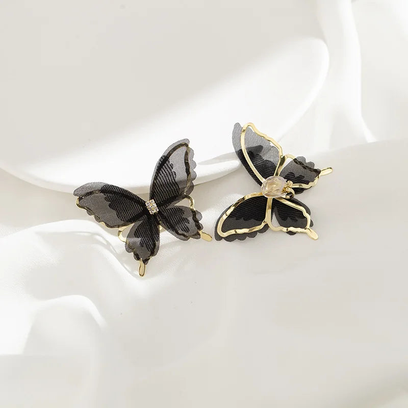 Elegant black butterfly clip-on earrings with chiffon fabric wings and luxurious gold-plated edges