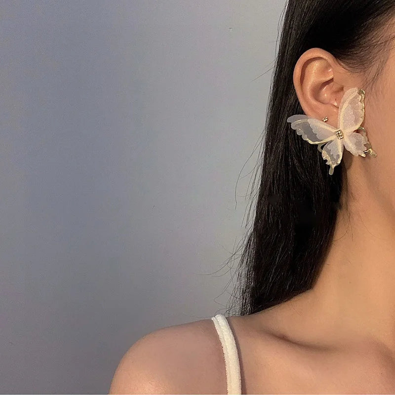 White silhouette butterfly wings clip-on earrings side view worn on ear with long dark hair