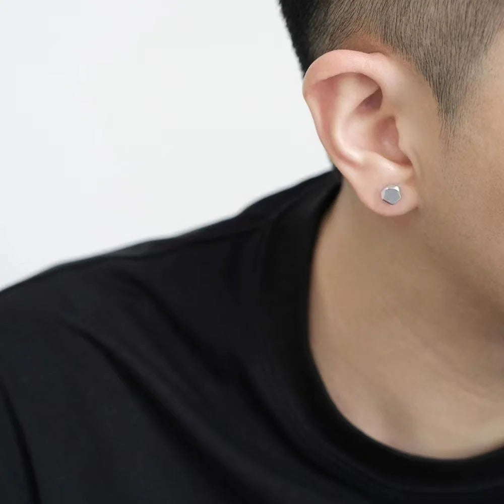 Silver polygon magnetic stud earrings worn on ear, side profile view against white background