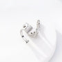 Silver snake ear cuff with zirconia accents displayed on white mannequin hand, side view