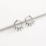 A pair of silver-toned hoop earrings with sharp spike details, displayed on a clean white surface.