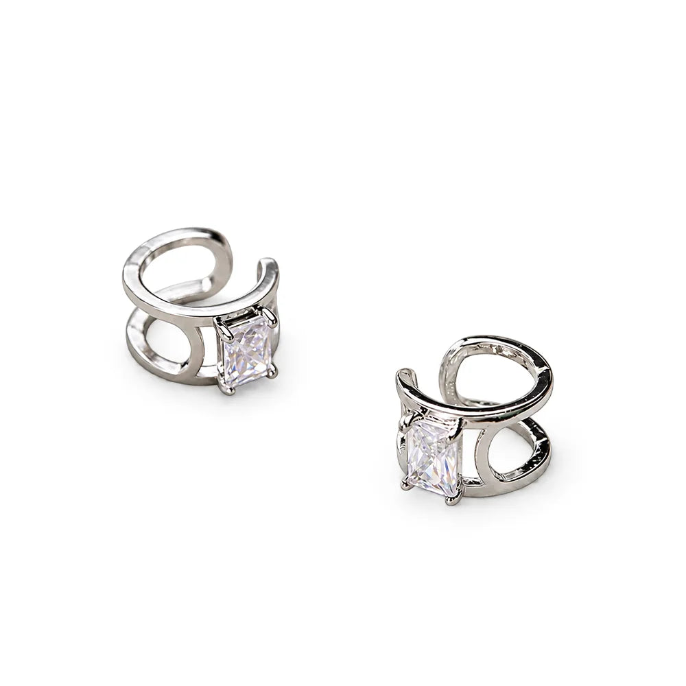 A pair of silver-toned hoop-style earrings with rectangular clear gemstones, shown on a clean white background.
