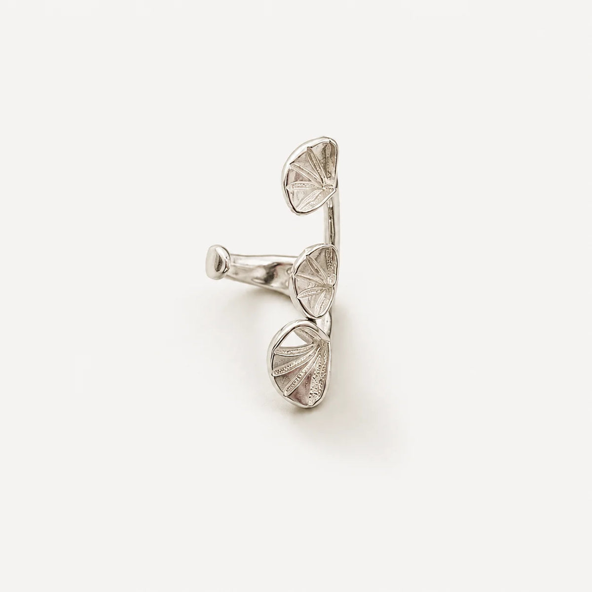 A silver cufflink designed like a branch with three textured, fan-like leaf or petal shapes, photographed on a clean, light off-white background.