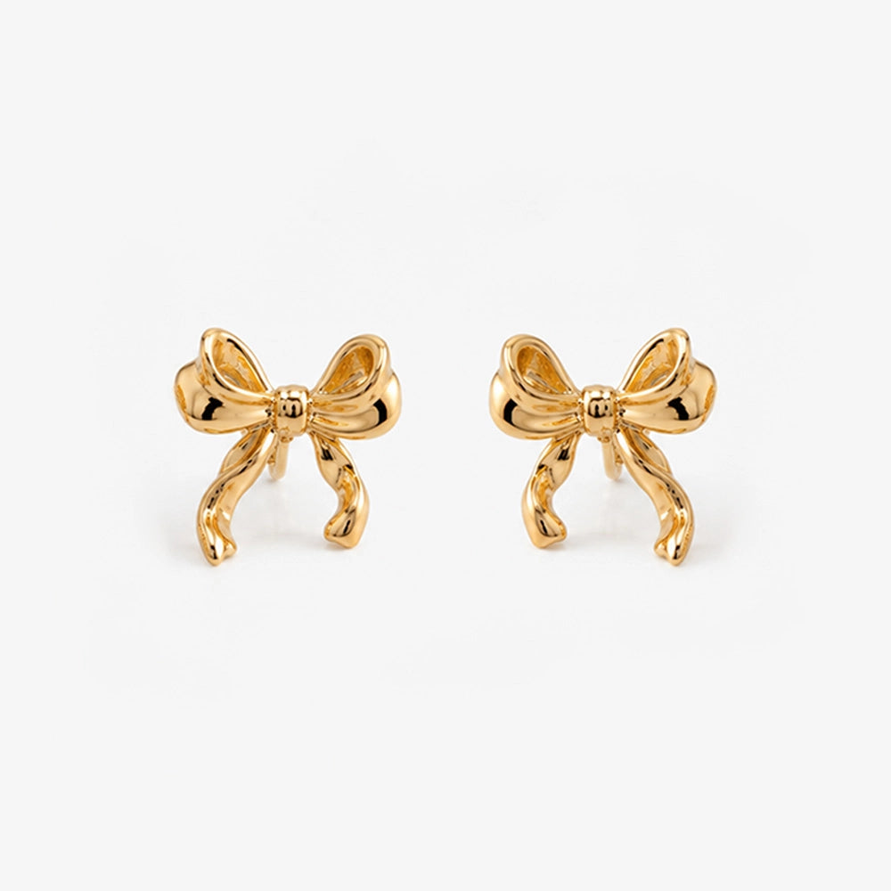 Gold simple bow clip on stud earrings front view on white background