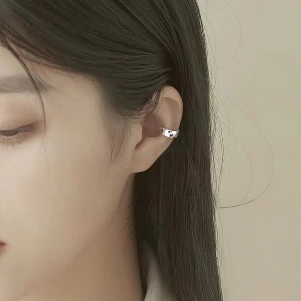 Silver conch ear cuff side view on model with dark hair showing sleek metallic design