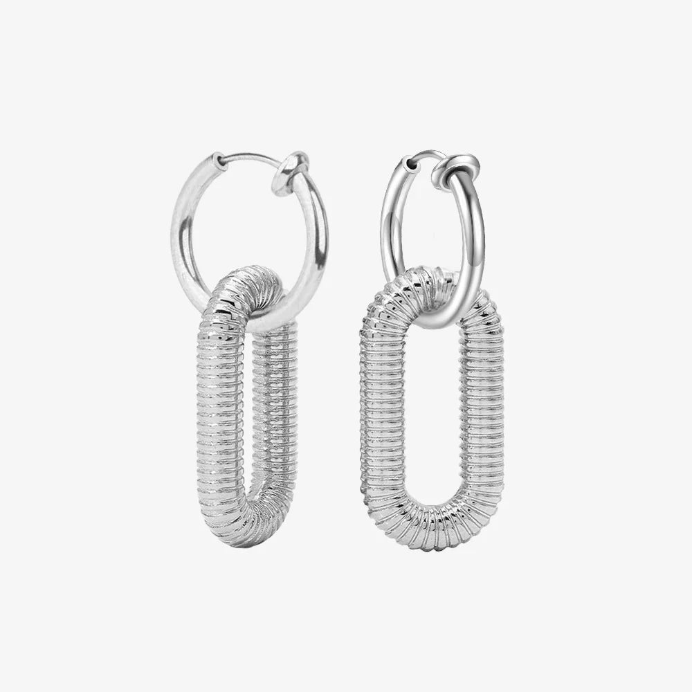 Pair of Slivery Spiral Clip-On Dangle Hoop Earrings displayed on a white surface, capturing the elegant and modern design.