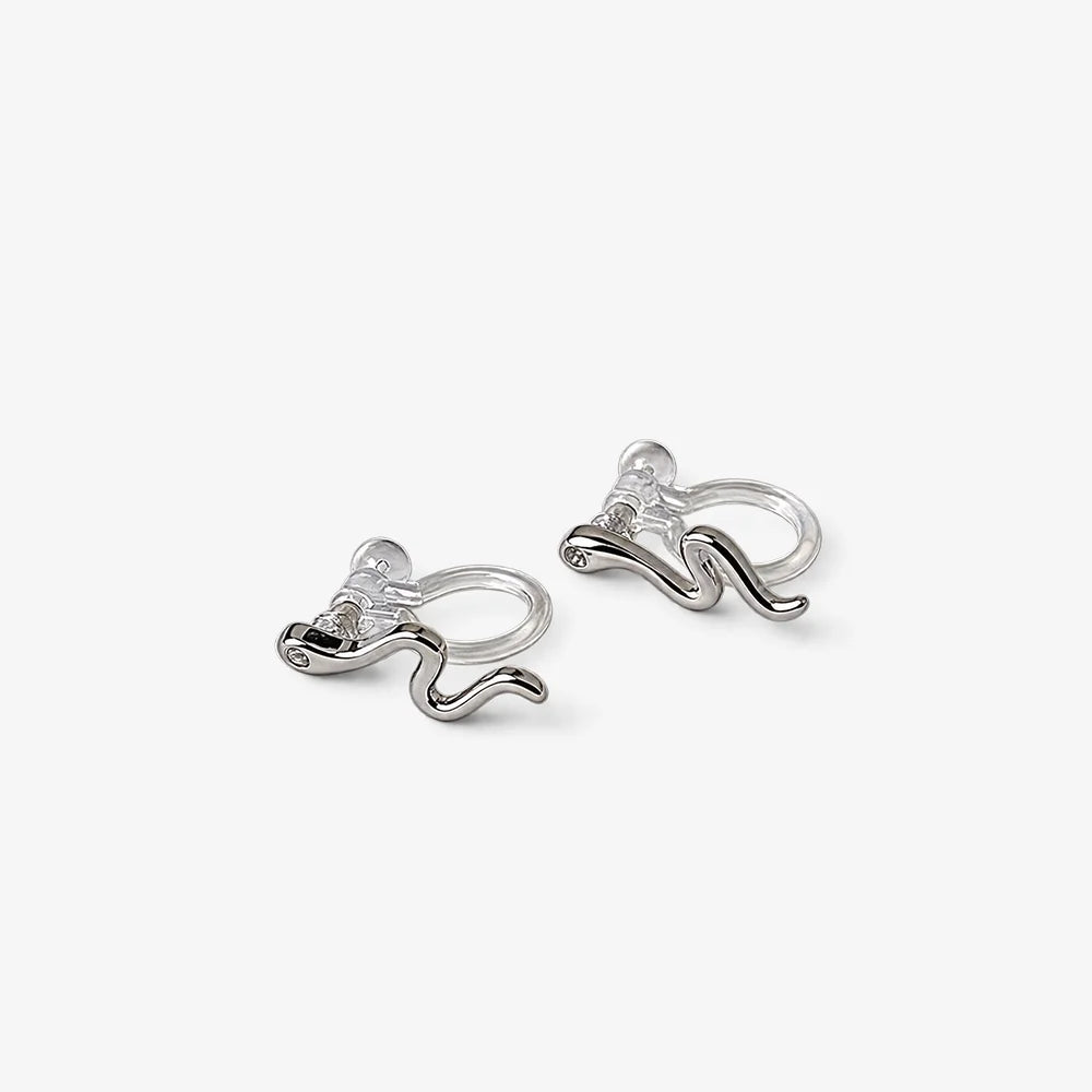 Silvery snake invisible clip-on stud earrings displayed on white surface, showing polished silver finish and curved design detail