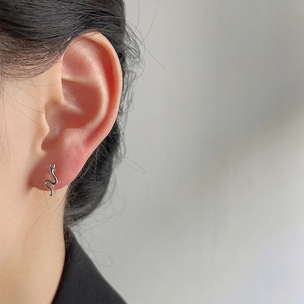 Silvery Snake Invisible Clip-On Stud Earrings side view on ear, silver metal finish, white background