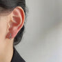 Silvery Snake Invisible Clip-On Stud Earrings side view on ear, silver metal finish, white background