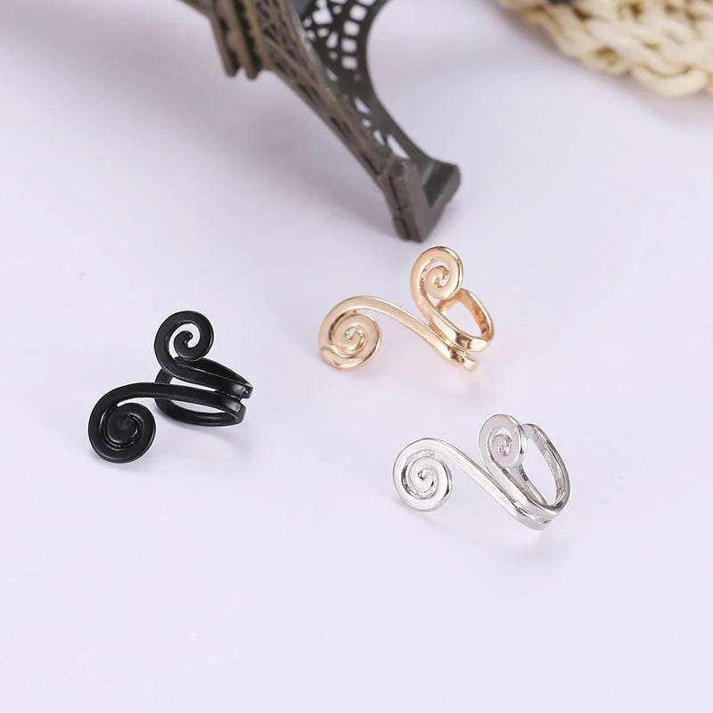 Spiral helix tragus cuff in silver, gold, and black displayed on white background with decorative lace
