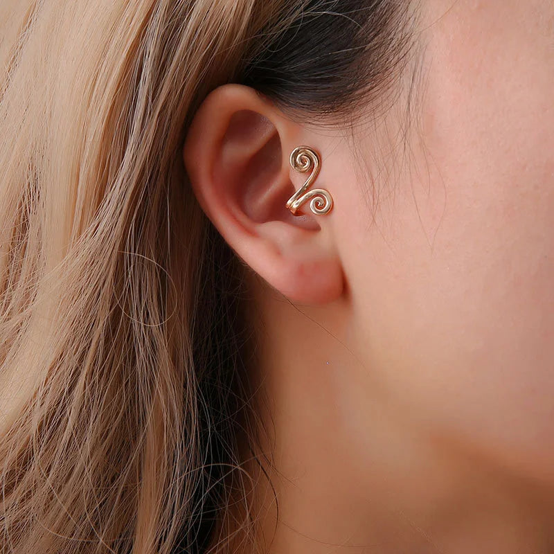 Spiral Helix Tragus Cuff in Gold, a lightweight ear cuff, displayed on a model's ear.