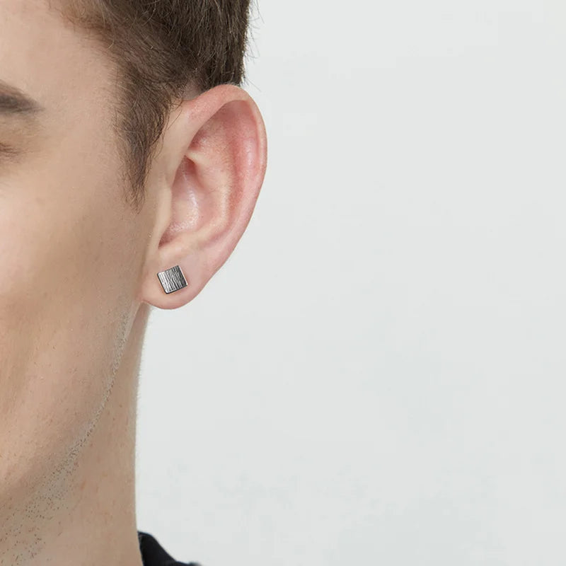 A man wearing Sterling Silver Tree Bark Texture Square Magnetic Earrings, showcasing their stylish, nature-inspired design.