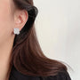 Square Pavé Clip-On Stud Earrings worn by a model, showcasing their elegant square design.
