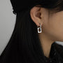 Modern minimalist square clip-on earrings in silver, side view worn on ear with long dark hair