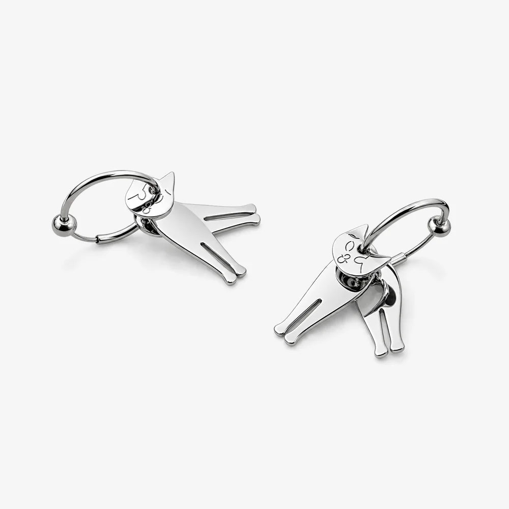 A pair of silver-toned hoop earrings with minimalist cat-shaped charms, displayed on a clean, light gray background.