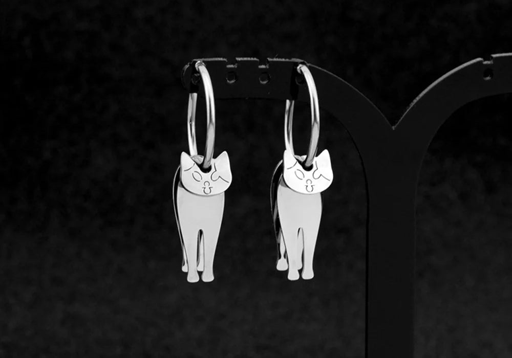 Stainless steel articulated cat clip-on earrings with hoop design, front view on black background