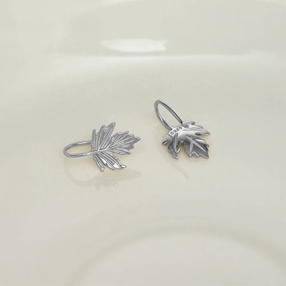 Close up of the intricate maple leaf design on the white gold cuff earrings.