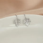Sterling silver maple leaf cuff earrings in white gold, displayed on white ceramic dish, front view