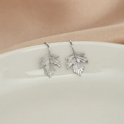 Showcase of the white gold-plated sterling silver finish on the Maple Leaf Cuff Earrings.