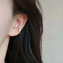 Gold sterling silver Ouroboros ear cuff side view worn on ear with long dark hair