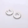 Diamond clip-on silver hoop earrings top view on white background showcasing sparkly round design