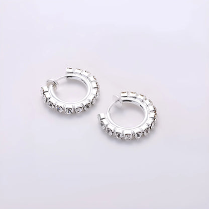 Small silver mini hoop earrings with a sliding spring-hoop clip-on mechanism, perfect for daily wear.