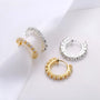 Diamond clip-on gold hoop earrings in white and yellow gold displayed on white fabric background