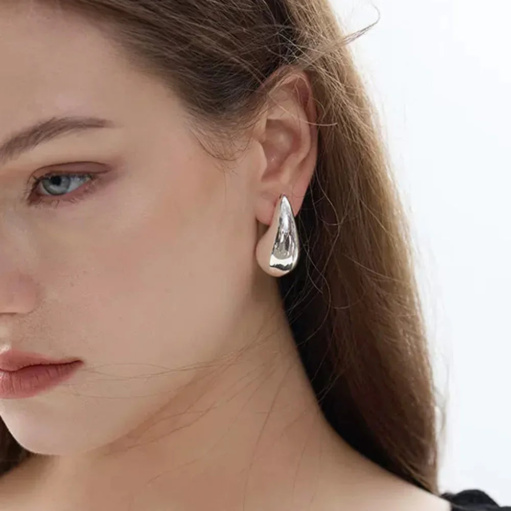 Silver teardrop clip-on earrings side view worn on model with white background