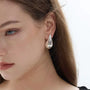 Silver teardrop clip-on earrings side view worn on model with white background