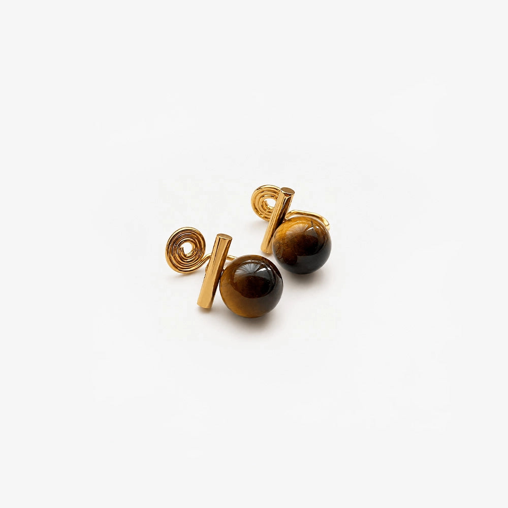 Tiger's Eye clip on earrings with gold accents displayed on white surface 