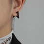 Black geometric triangle clip-on earrings side view worn on ear against white background