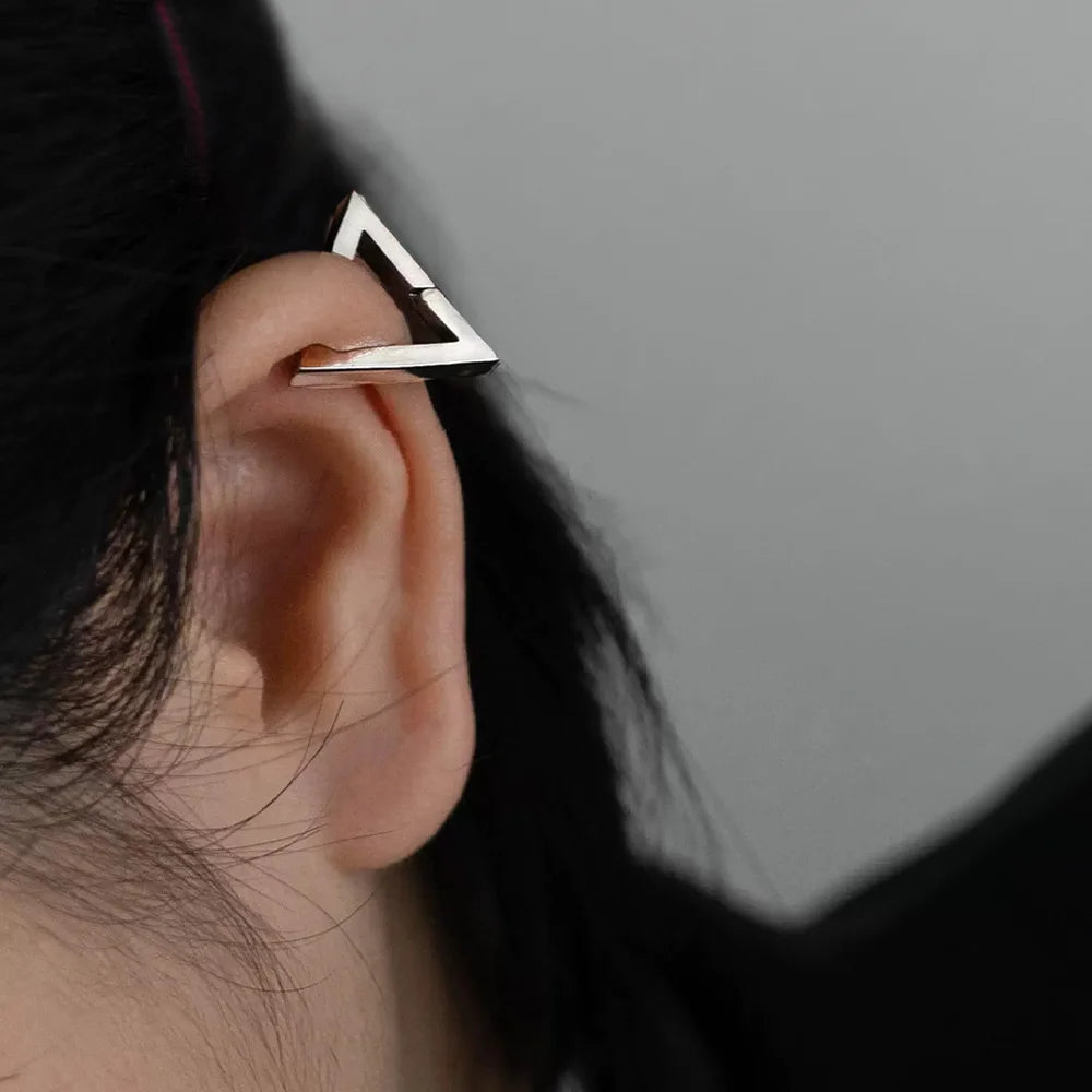 Silver geometric triangle clip-on earring worn on ear, side view showcasing modern minimalist design and polished metal finish