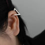Silver geometric triangle clip-on earring worn on ear, side view showcasing modern minimalist design and polished metal finish