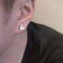 Triangle magnetic stud earrings in silver worn on ear, side profile view showing minimalist geometric design and polished finish