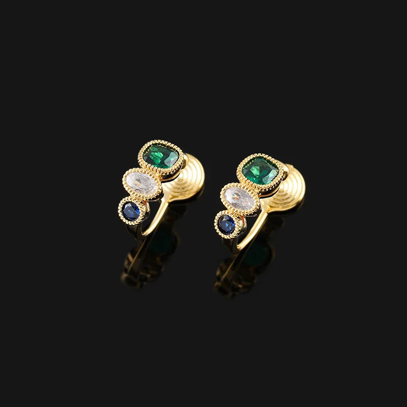 Triple Color Rhinestone Emerald Clip-On Earrings in gold with green, white and blue stones, front view on black background