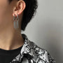Silver triple rod tassel clip-on earrings side view worn on ear with black outfit