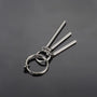 Silver triple rod tassel clip-on earrings angled view on gray background