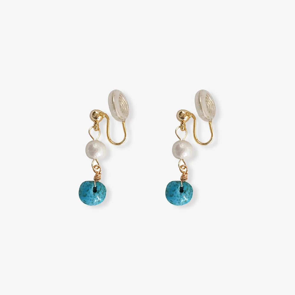 Turquoise clip on pearl earrings with gold hardware front view on white background