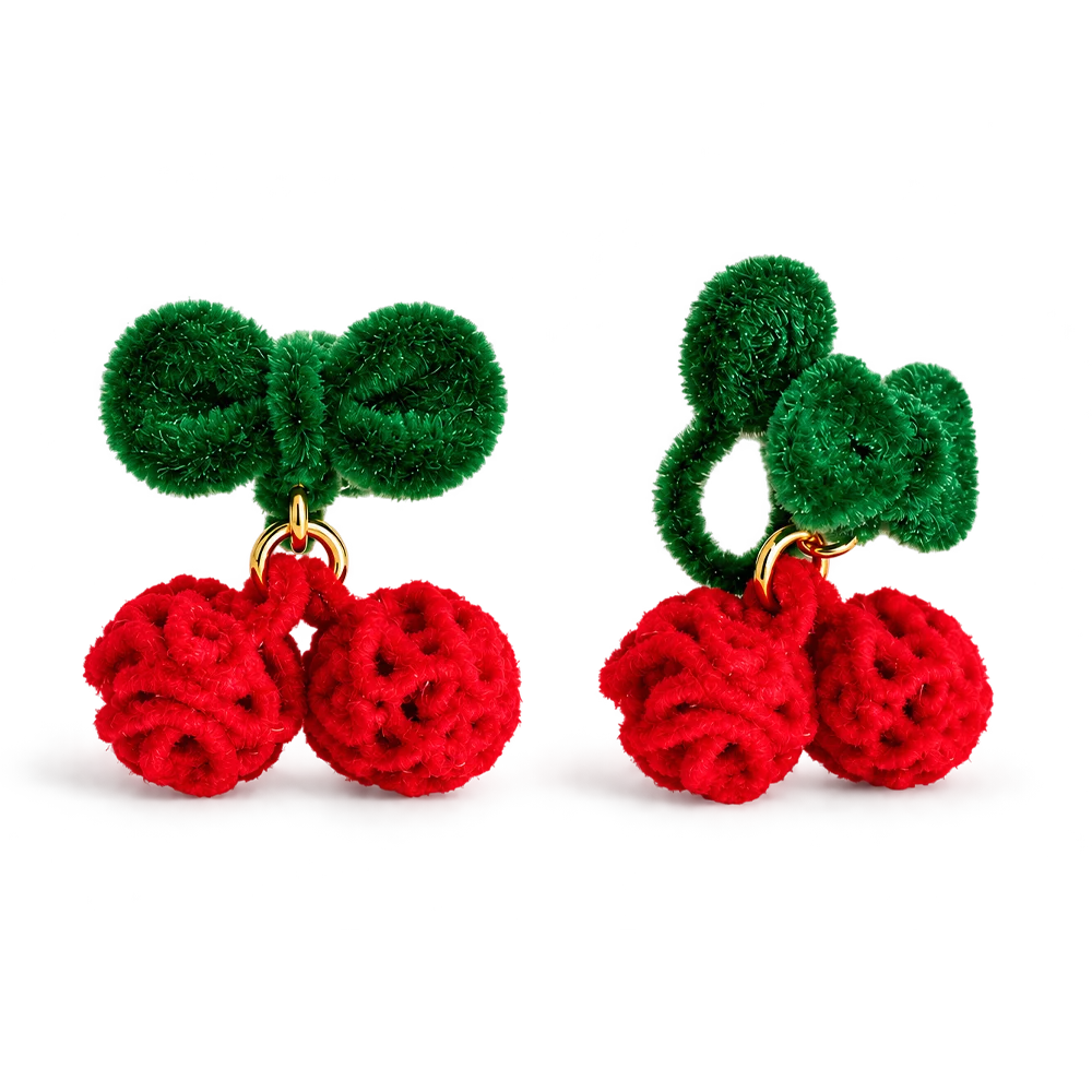 A pair of cherry-shaped earrings made from fuzzy green and red yarn, with gold-tone metal rings connecting the stems, shown on a plain white background.