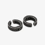A pair of textured black metal huggie hoop earrings with a hammered finish.
