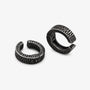 A pair of textured black metal huggie hoop earrings with a hammered finish, displayed in side view.