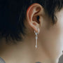 Silver Warrior Arrow clip-on earrings side view on model wearing ornate hoop design with dangling arrow pendant